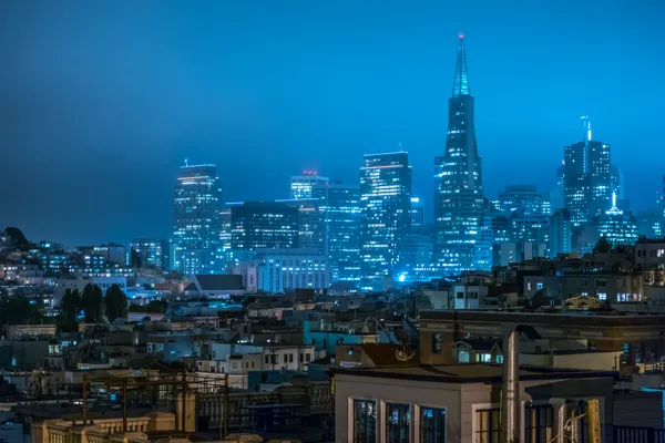 Downtown San Francisco at dusk, the Transamerica Pyramid lit against a blue sky